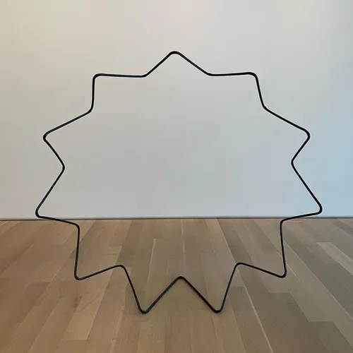 A black star-shaped wire sculpture, 'Vertical Expander' by Jonathan Muecke, from the Open Objects exhibit